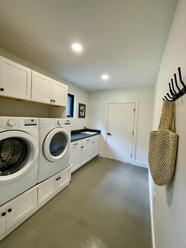 clothes washing area featuring cabinets and washing machine and clothes dryer