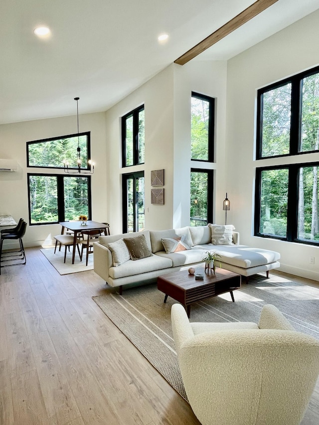 living room featuring light wood-type flooring, a wall mounted AC, and an inviting chandelier