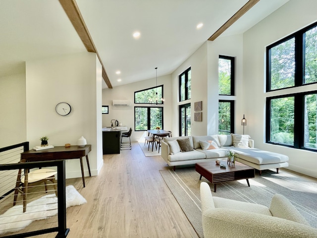 living room with an inviting chandelier, light hardwood / wood-style floors, an AC wall unit, and high vaulted ceiling