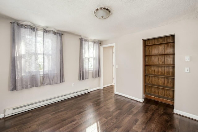 unfurnished room with baseboard heating, a textured ceiling, and dark hardwood / wood-style flooring