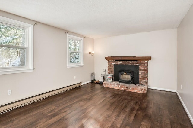 living room featuring a healthy amount of sunlight, a baseboard heating unit, dark wood-type flooring, and a textured ceiling