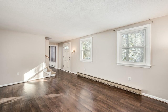 spare room featuring dark hardwood / wood-style flooring, a baseboard radiator, and a textured ceiling