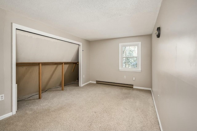 unfurnished bedroom with a closet, a textured ceiling, baseboard heating, and light carpet