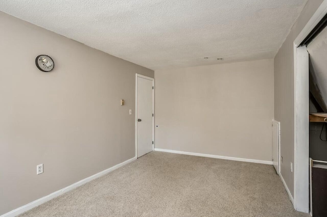 carpeted empty room featuring a textured ceiling