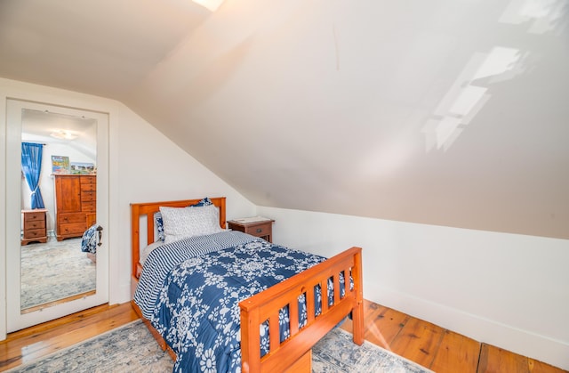 bedroom featuring vaulted ceiling and hardwood / wood-style floors