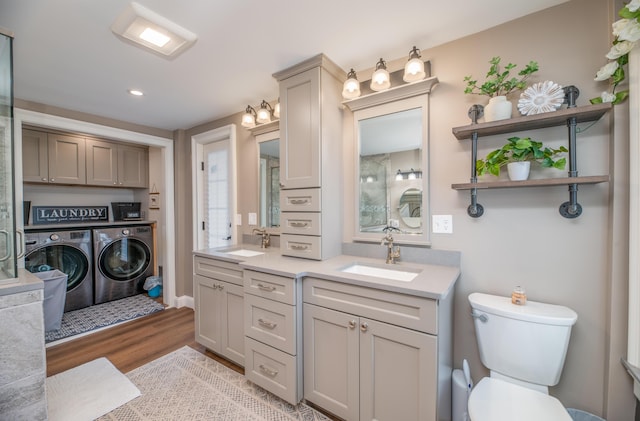 bathroom featuring toilet, vanity, wood-type flooring, and washer and dryer