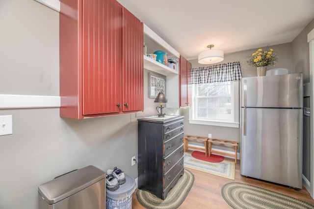 kitchen with stainless steel fridge and light hardwood / wood-style flooring