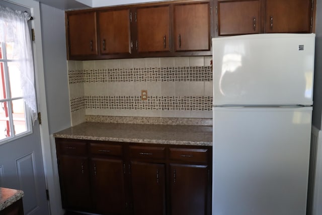 kitchen featuring white fridge, plenty of natural light, and tasteful backsplash