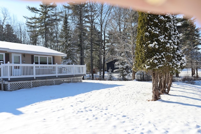 yard covered in snow featuring a wooden deck