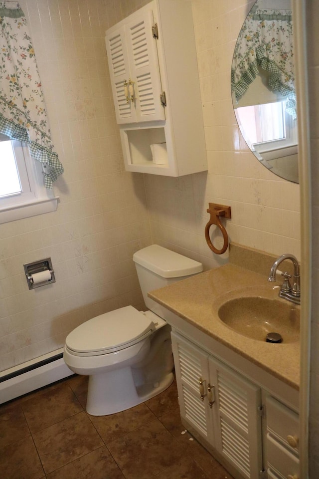 bathroom featuring a baseboard radiator, tile patterned flooring, toilet, vanity, and tile walls