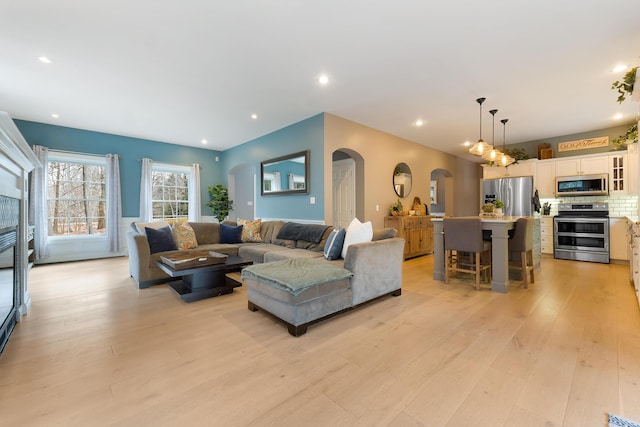 living room with light hardwood / wood-style floors and a tiled fireplace