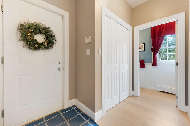 foyer with light wood-type flooring and a baseboard radiator