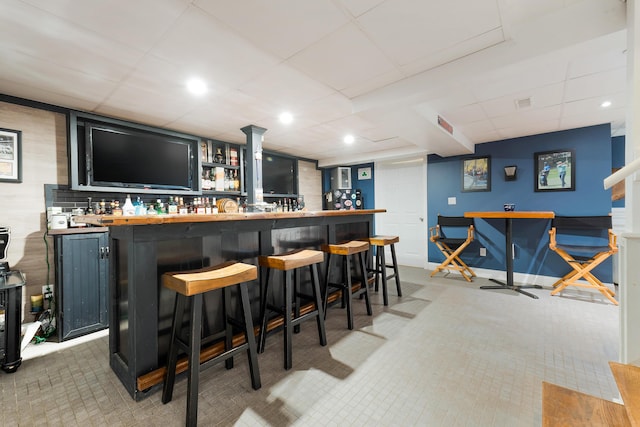 bar featuring wood counters and a paneled ceiling