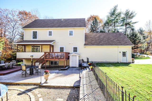 back of property with a deck, a yard, and a patio