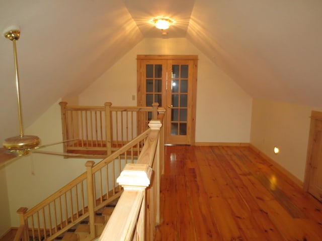 bonus room with hardwood / wood-style flooring, lofted ceiling, and french doors