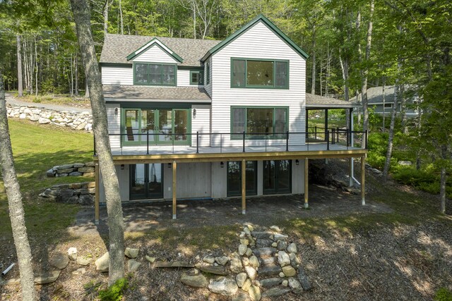 31 Viking Way, Bristol, ME 04539 - back of property with roof with shingles, a wooden deck, and view of wooded area