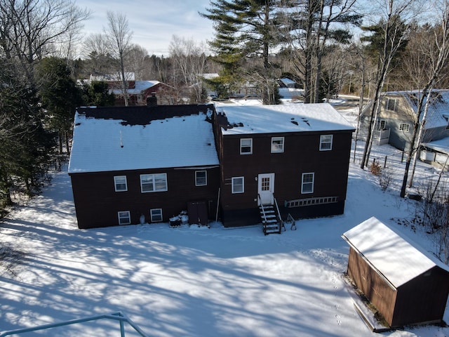 view of snow covered back of property