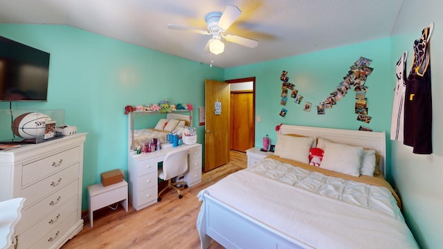 bedroom with ceiling fan, light wood-type flooring, and vaulted ceiling