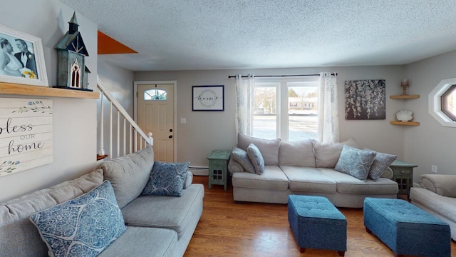 living room featuring a textured ceiling, wood-type flooring, and a baseboard radiator