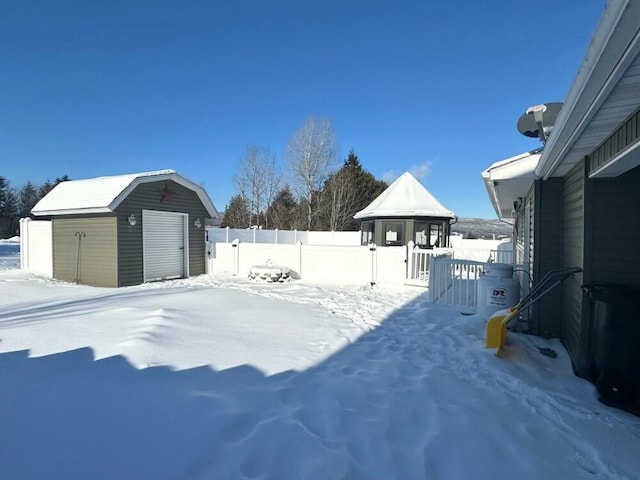 snowy yard featuring a storage unit