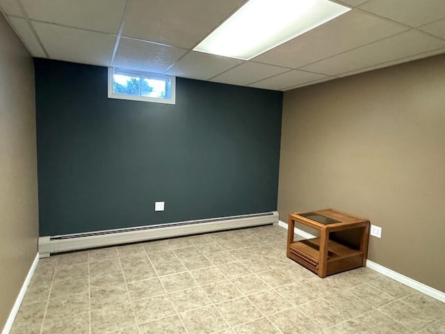 basement featuring a baseboard radiator and a drop ceiling