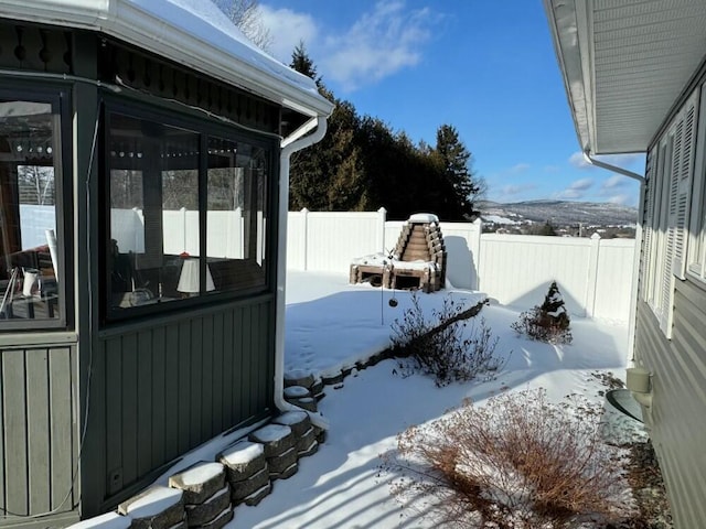 snowy yard with a sunroom