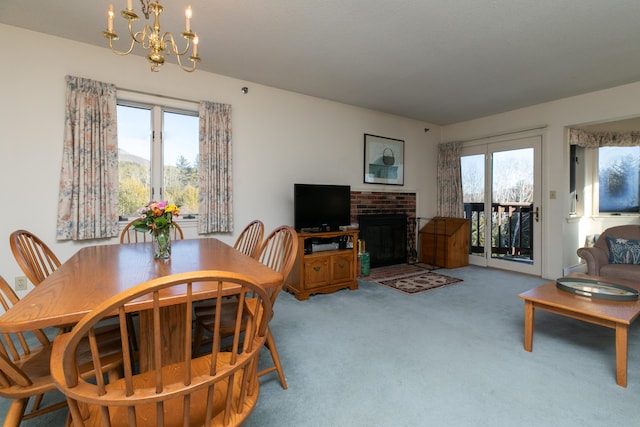 carpeted dining room with a fireplace, an inviting chandelier, and a wealth of natural light