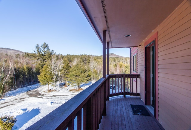 snow covered back of property featuring a mountain view