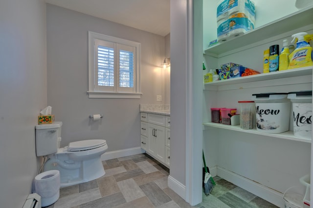 bathroom with toilet, vanity, and a baseboard radiator