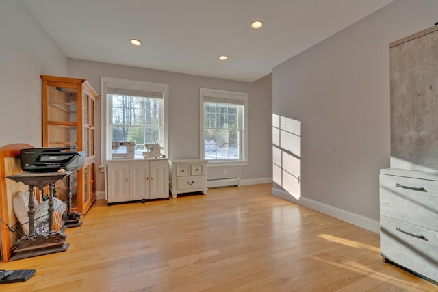 office space featuring a baseboard radiator and light hardwood / wood-style flooring