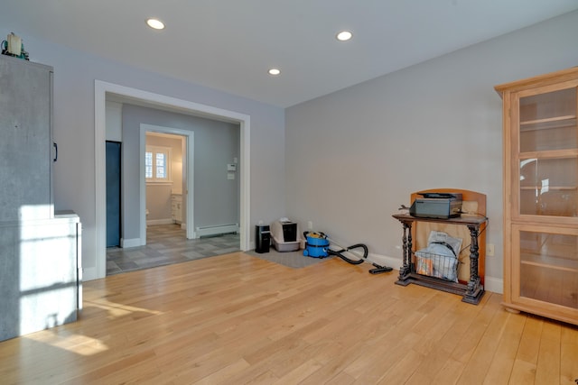 spare room featuring a baseboard radiator and light hardwood / wood-style floors