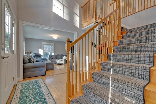 staircase with a high ceiling and hardwood / wood-style floors