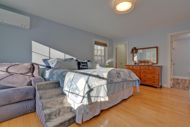 bedroom featuring hardwood / wood-style floors and a wall mounted AC