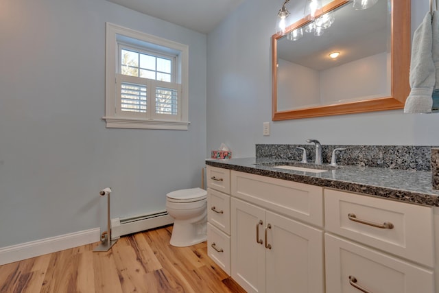 bathroom with vanity, a baseboard radiator, toilet, and hardwood / wood-style flooring