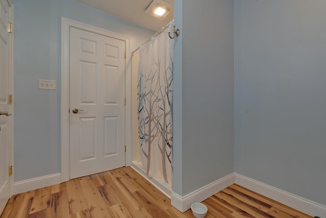 interior space with wood-type flooring and a shower with curtain