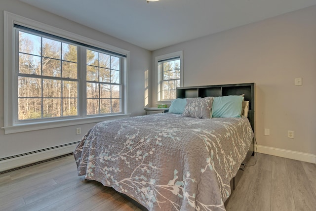 bedroom featuring a baseboard radiator and light hardwood / wood-style floors