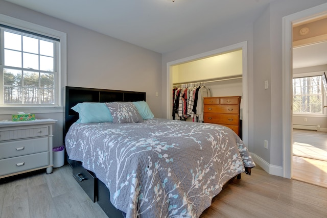 bedroom with light hardwood / wood-style flooring, a closet, and a baseboard radiator