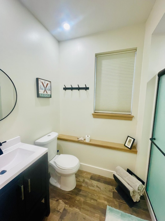 bathroom featuring toilet, vanity, and hardwood / wood-style flooring