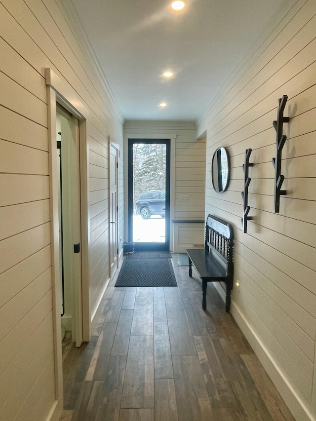 doorway to outside featuring wood walls and dark hardwood / wood-style floors