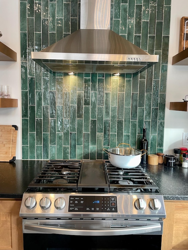 kitchen featuring decorative backsplash, gas range, and wall chimney exhaust hood