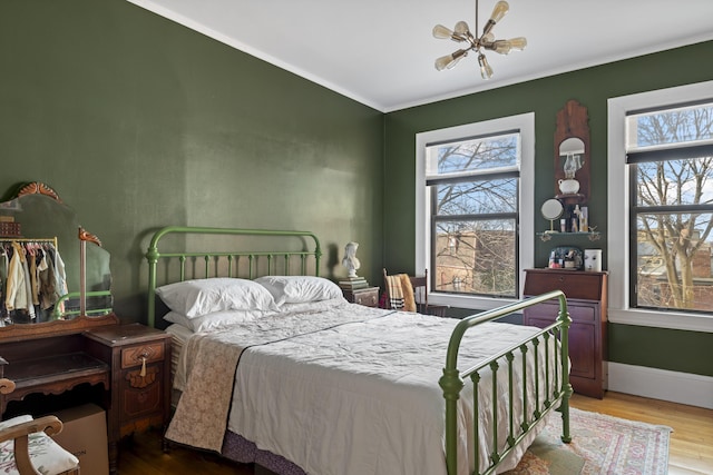 bedroom featuring a chandelier, hardwood / wood-style flooring, and multiple windows