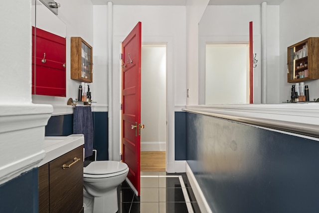 bathroom featuring tile patterned flooring, vanity, and toilet