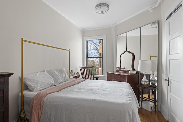 bedroom with wood-type flooring, ornamental molding, and a closet