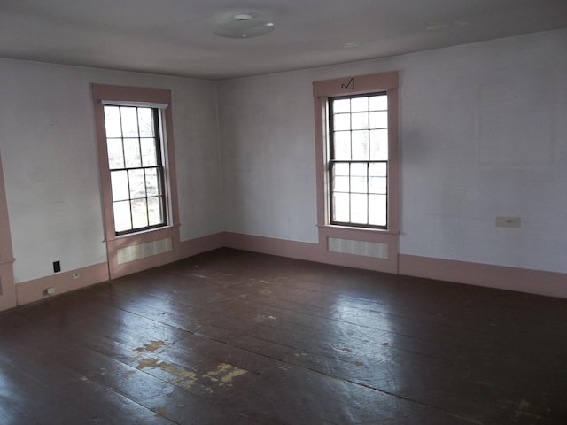 spare room with dark hardwood / wood-style floors and a wealth of natural light