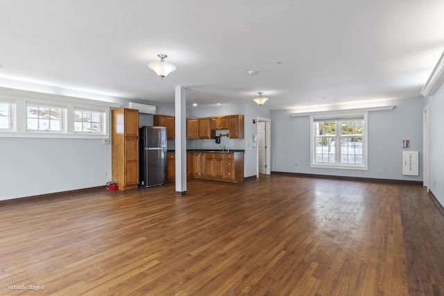 unfurnished living room with dark wood finished floors and baseboards