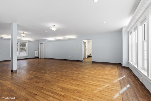 unfurnished living room featuring baseboards and wood finished floors