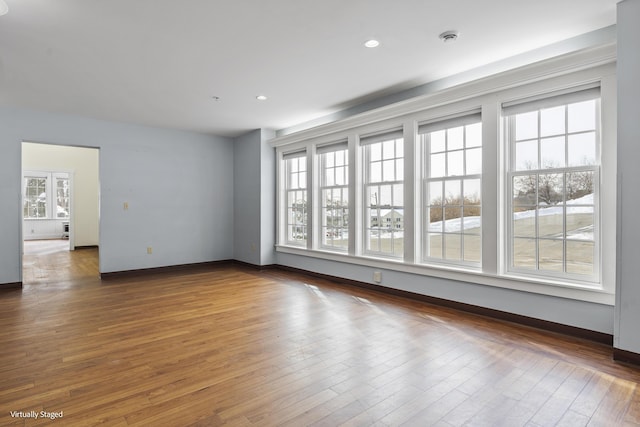 empty room featuring dark wood-style flooring, recessed lighting, and baseboards