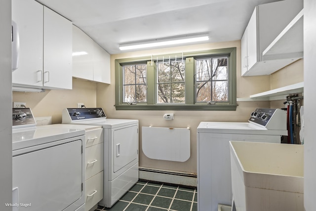 clothes washing area with a baseboard heating unit, cabinet space, a sink, and washer and clothes dryer