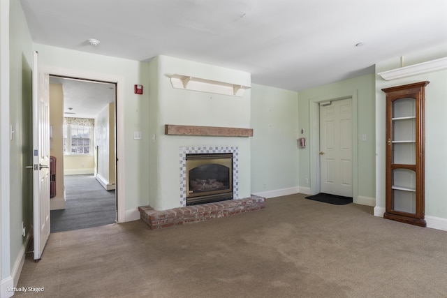 unfurnished living room with a fireplace, baseboards, and carpet flooring