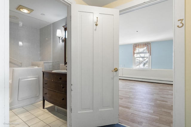 bathroom with tile patterned flooring, baseboard heating, and vanity